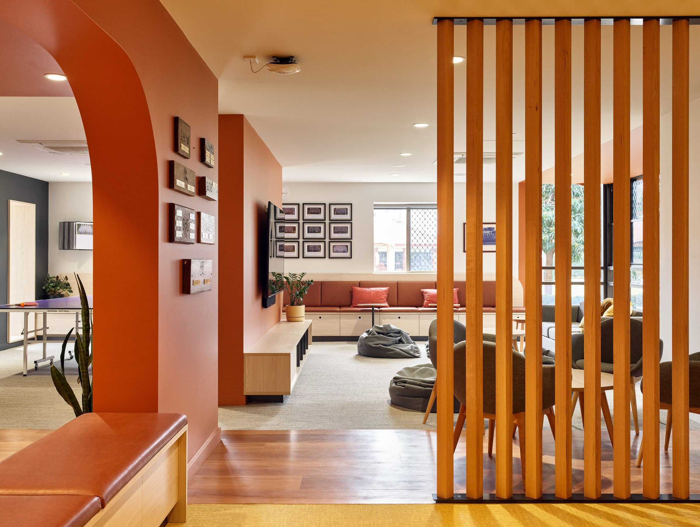 Common area seen through timber battens and an arched opening.