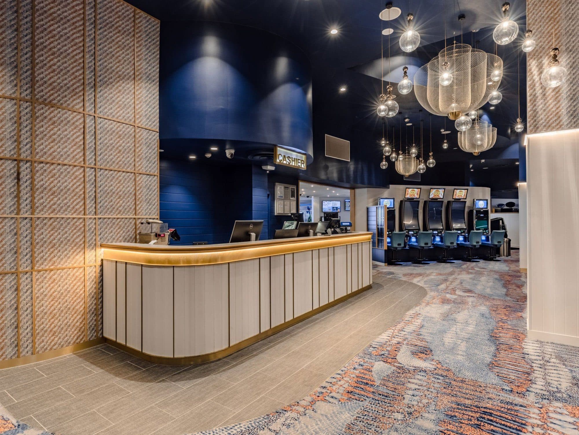 The timber-fronted cashier and reception counter at the end of the gaming room.