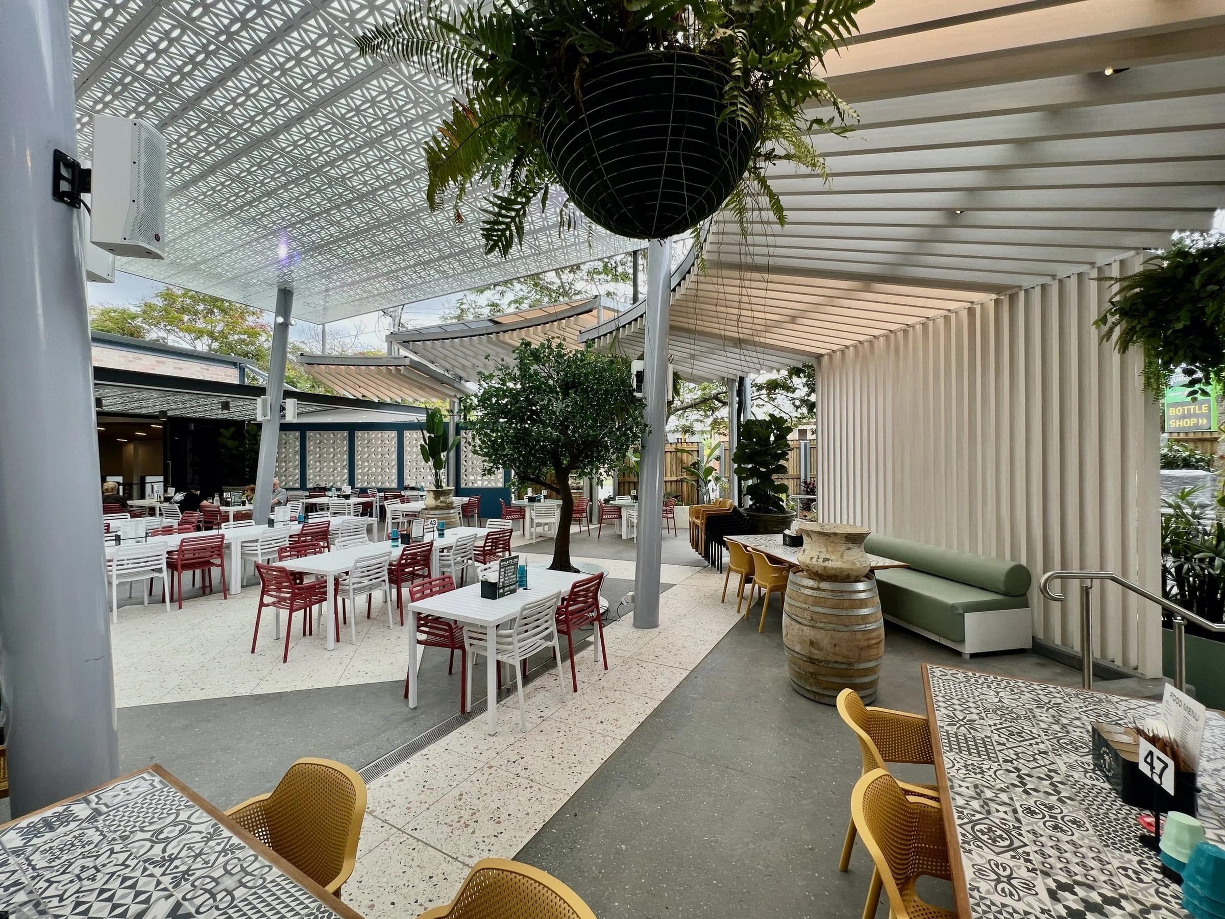 The courtyard dining area under an operable louvre roof.