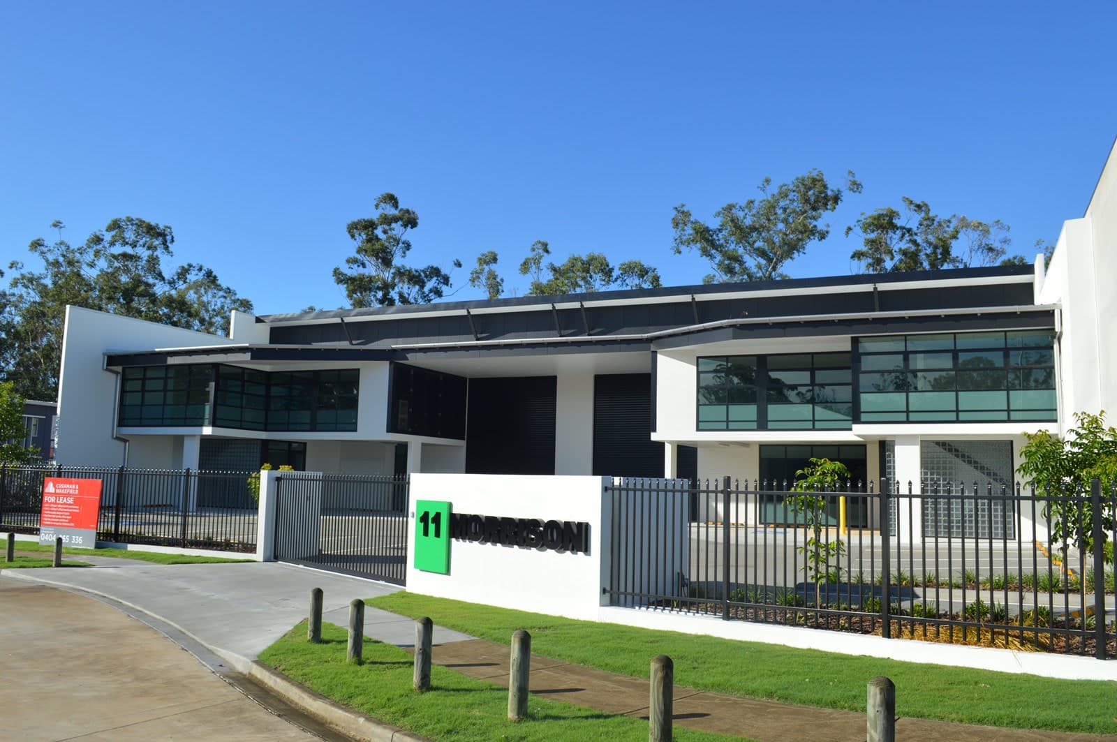 The street frontage with the two units behind a landscaped entry and fencing.