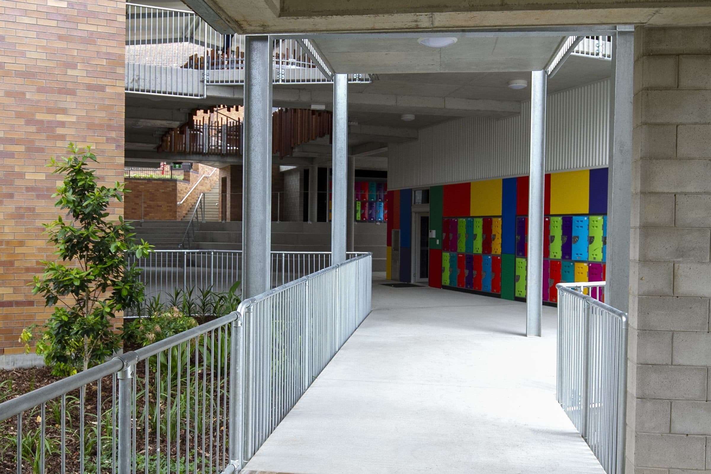 A covered walkway lined with brightly coloured lockers.