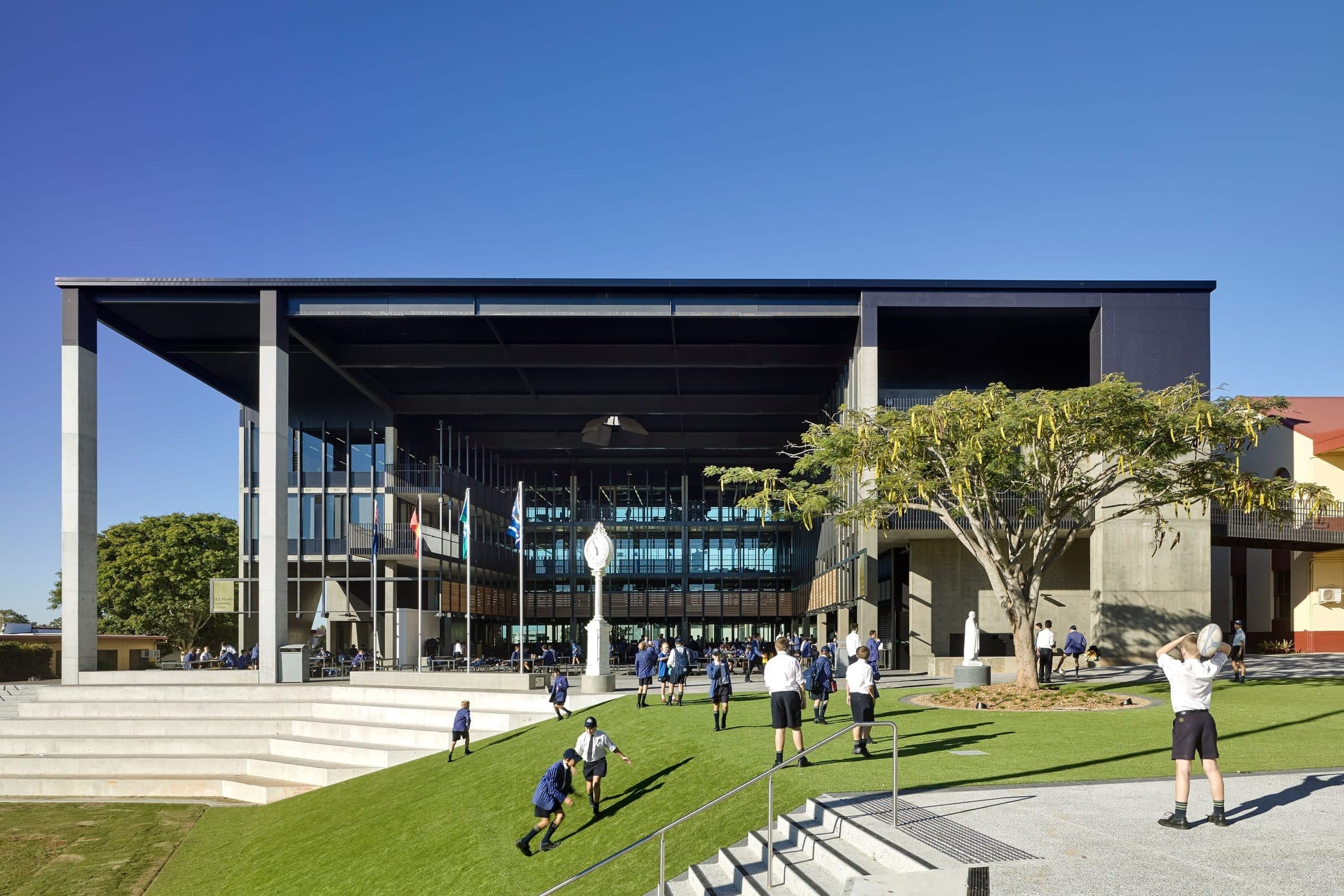 The entry forecourt and stairs with students crossing the lawn.