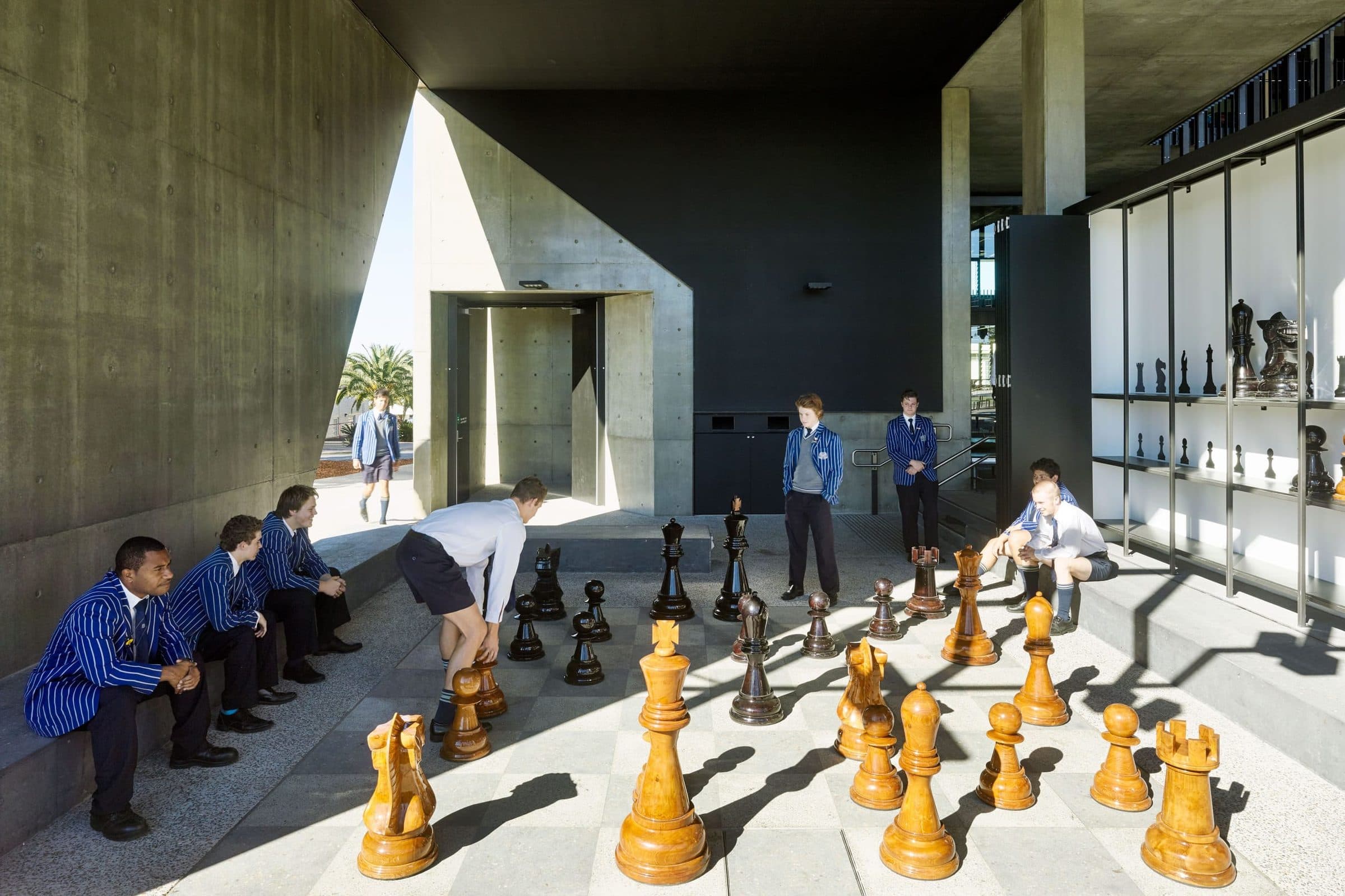 Students at the giant chess board under the concrete canopy.