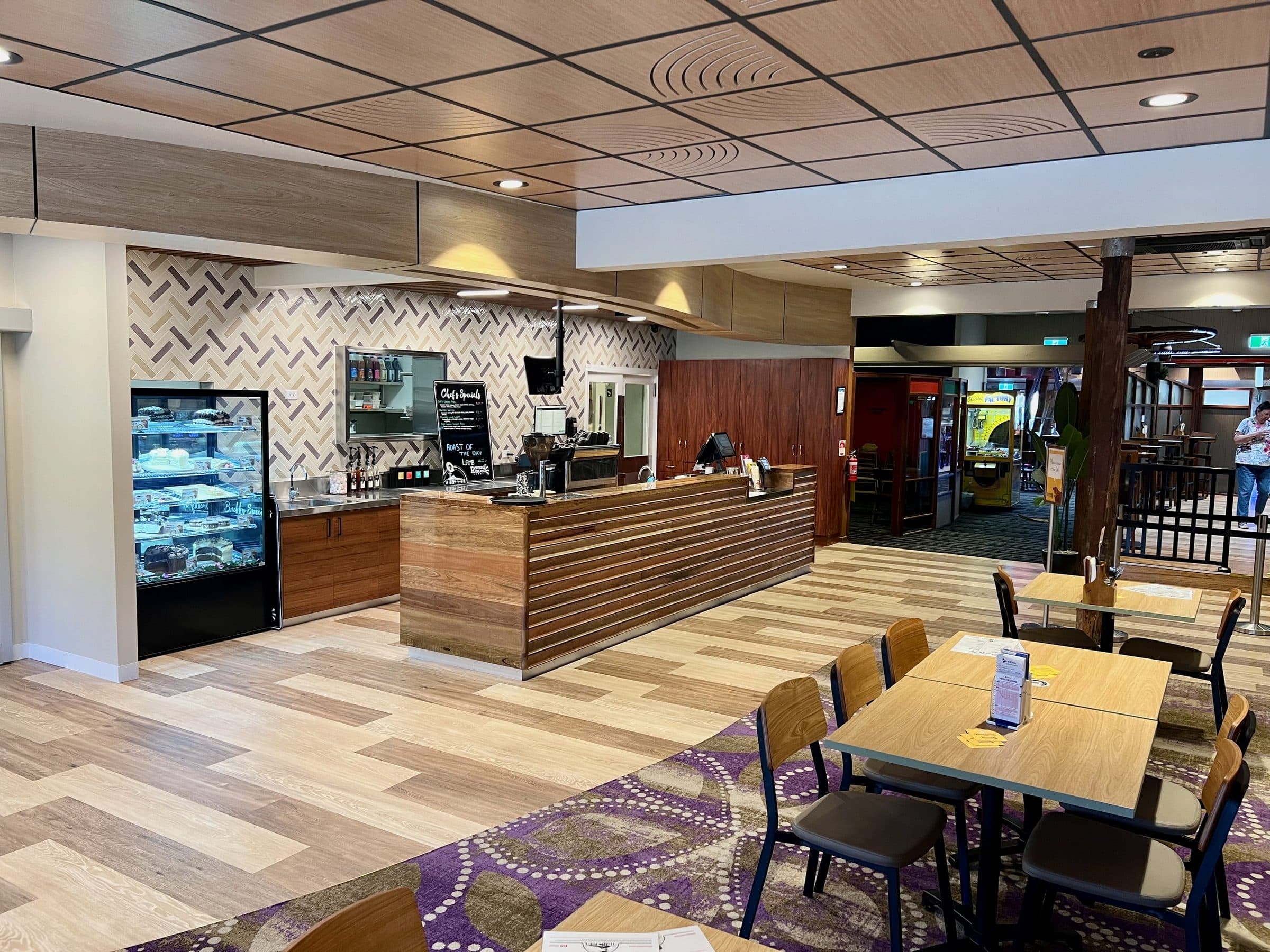 The servery with display fridges and a feature tiled wall.