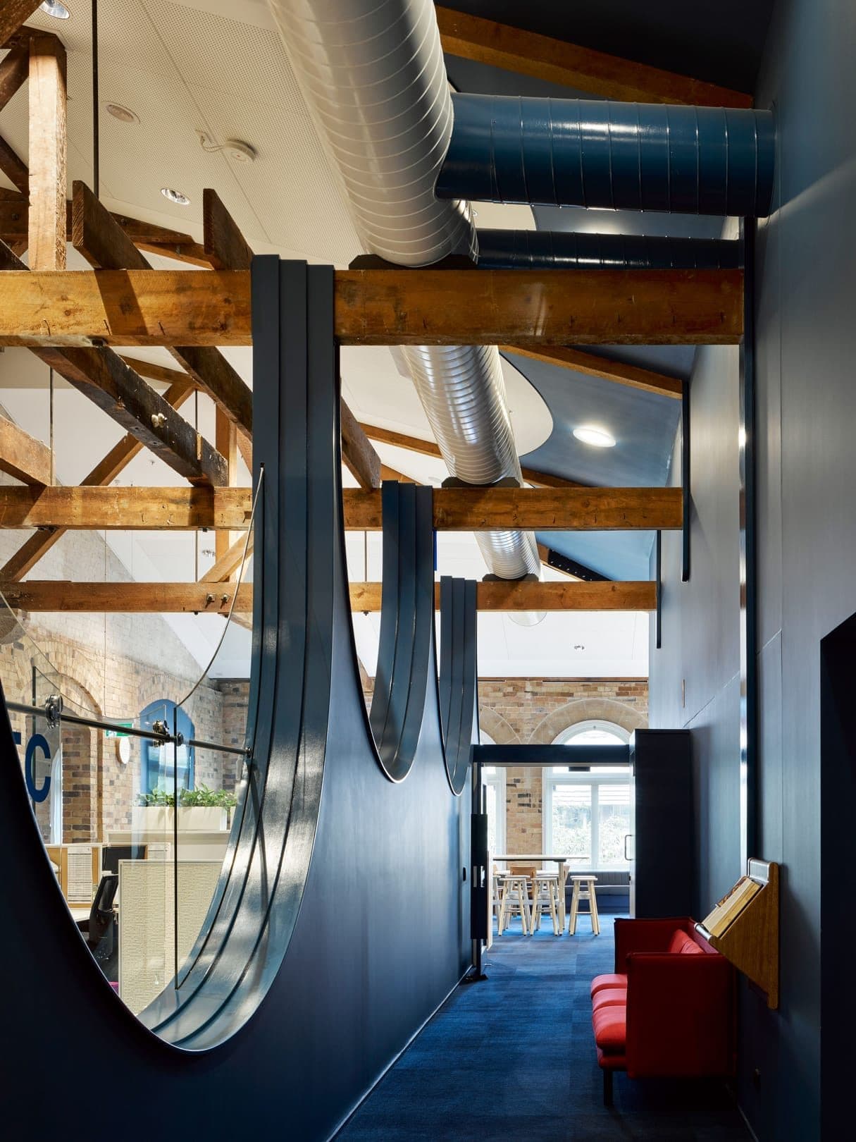Curved partitions running between the timber trusses.
