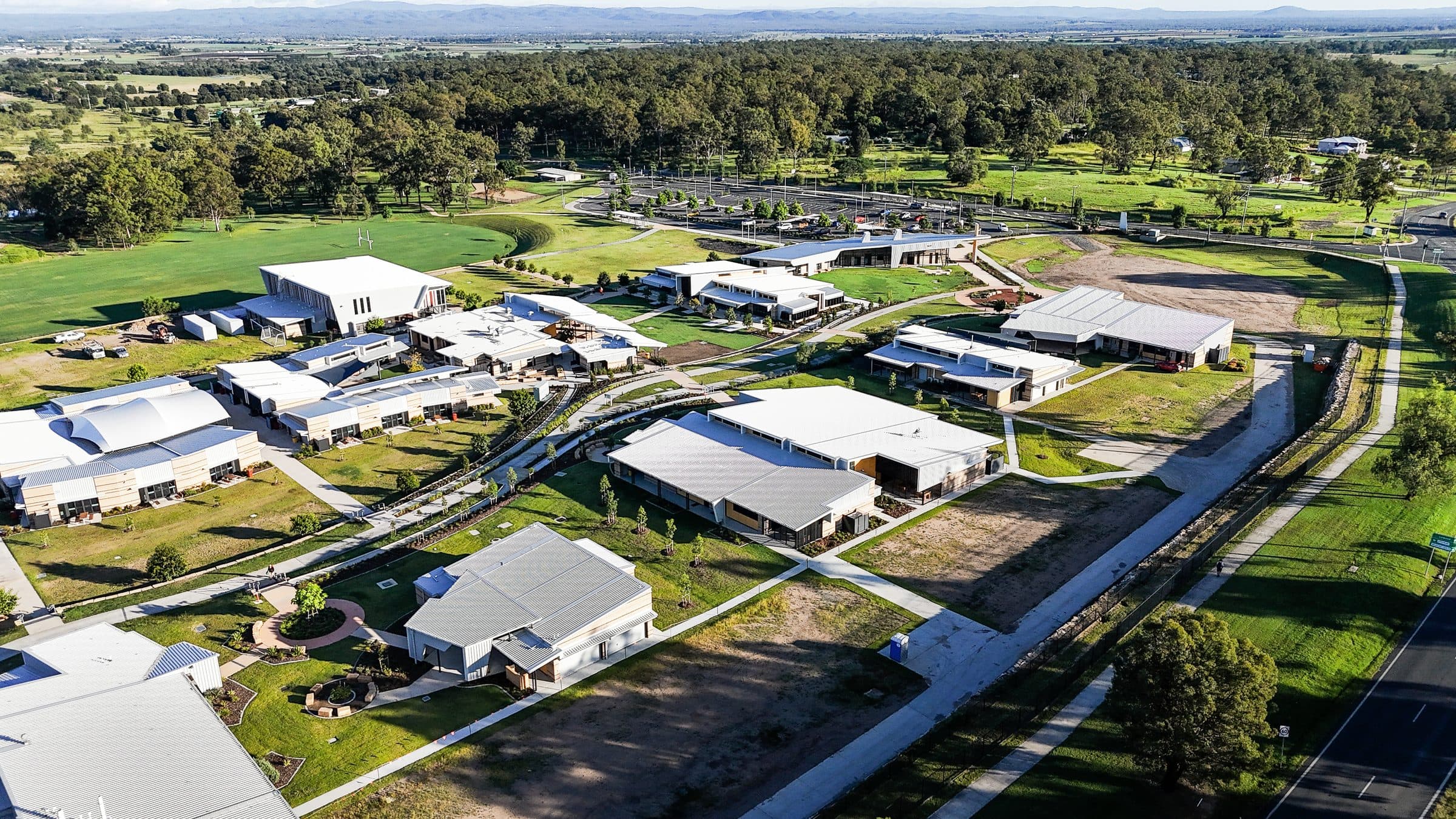 The campus from the air, looking across the buildings and open country towards the range.