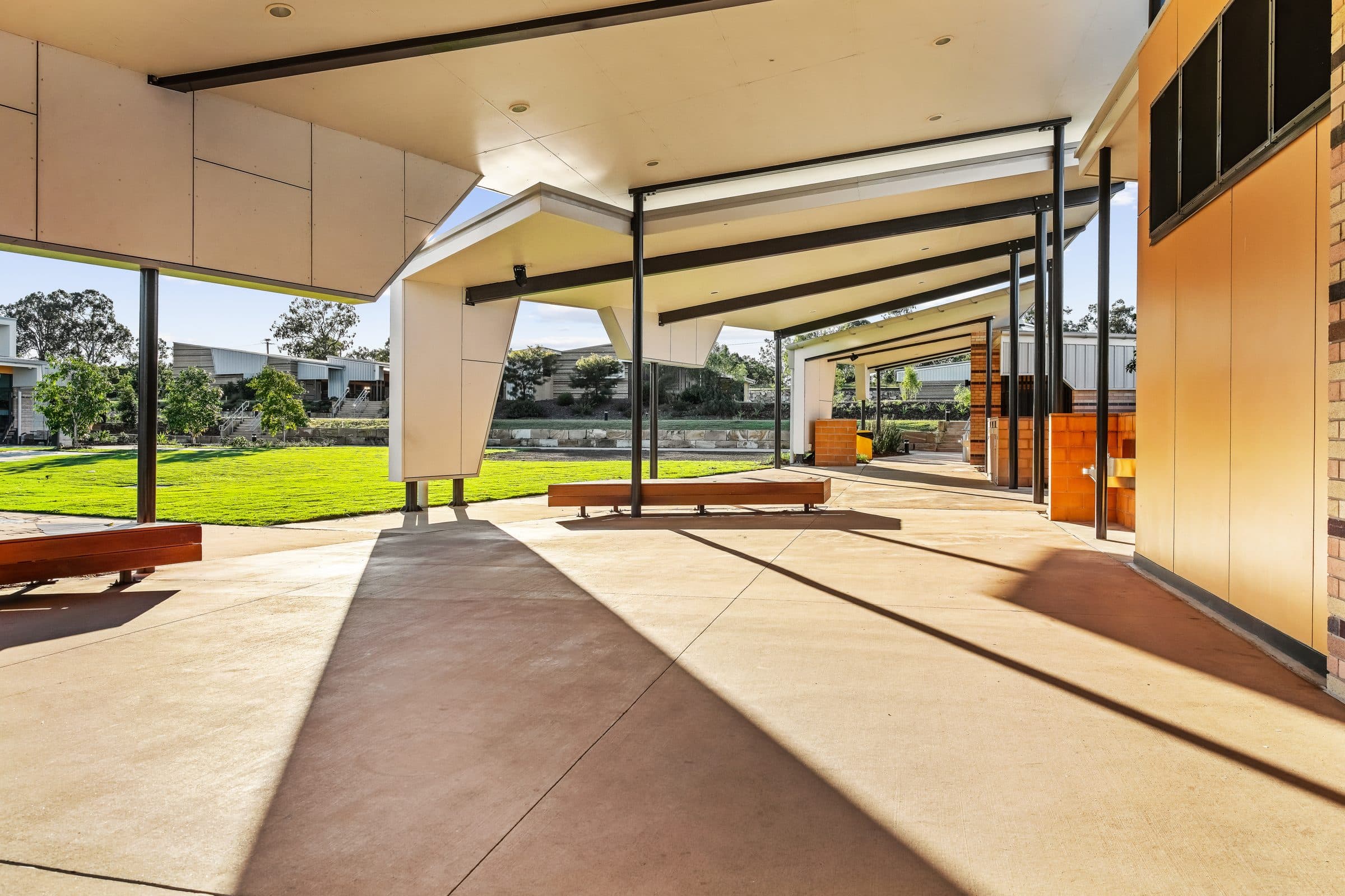 The covered outdoor learning area, with timber benches under a steel-framed roof.